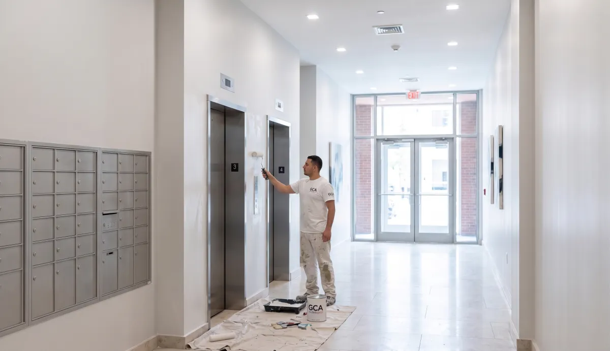 GCA Painting crew member painting an elevator door in a condominium building lobby