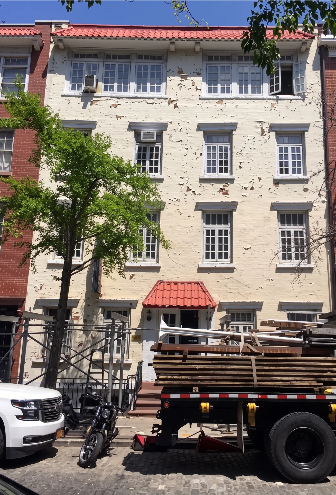Peeling, weathered paint on a NYC apartment building facade before repainting