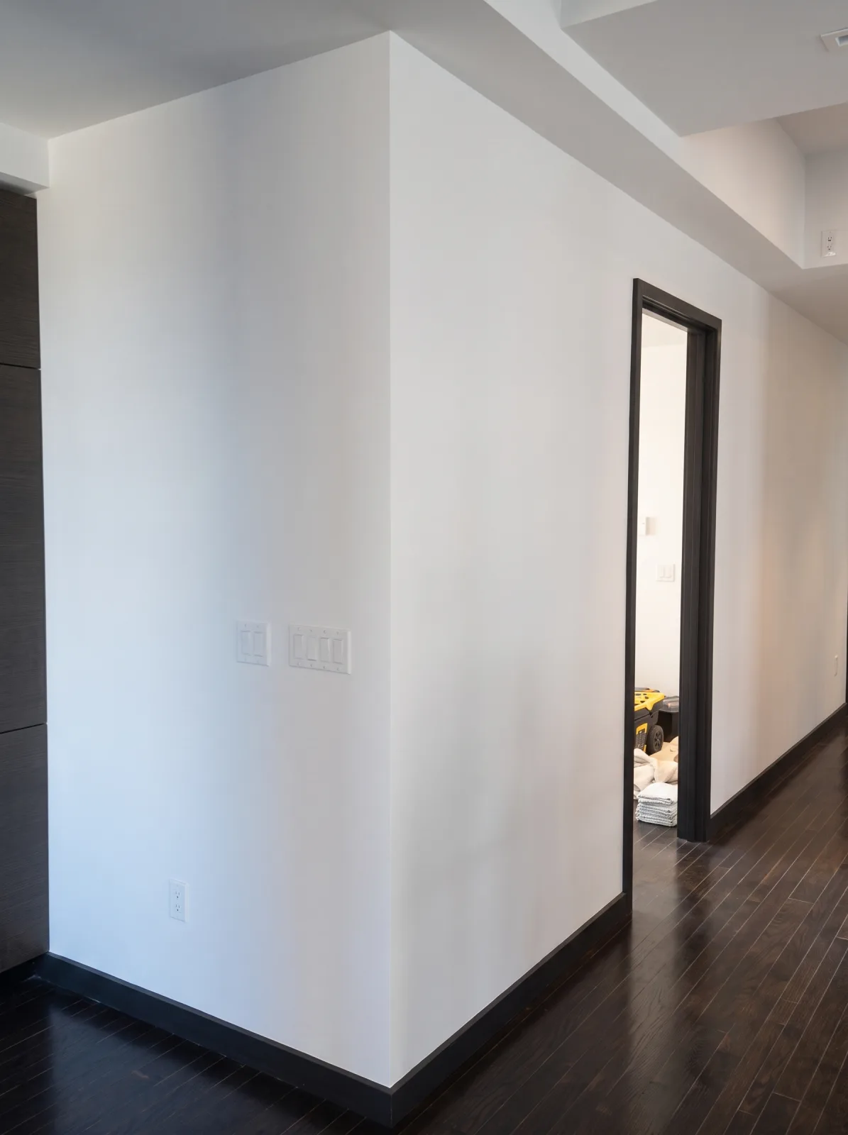 Freshly painted white wall corner with dark trim in a NYC apartment
