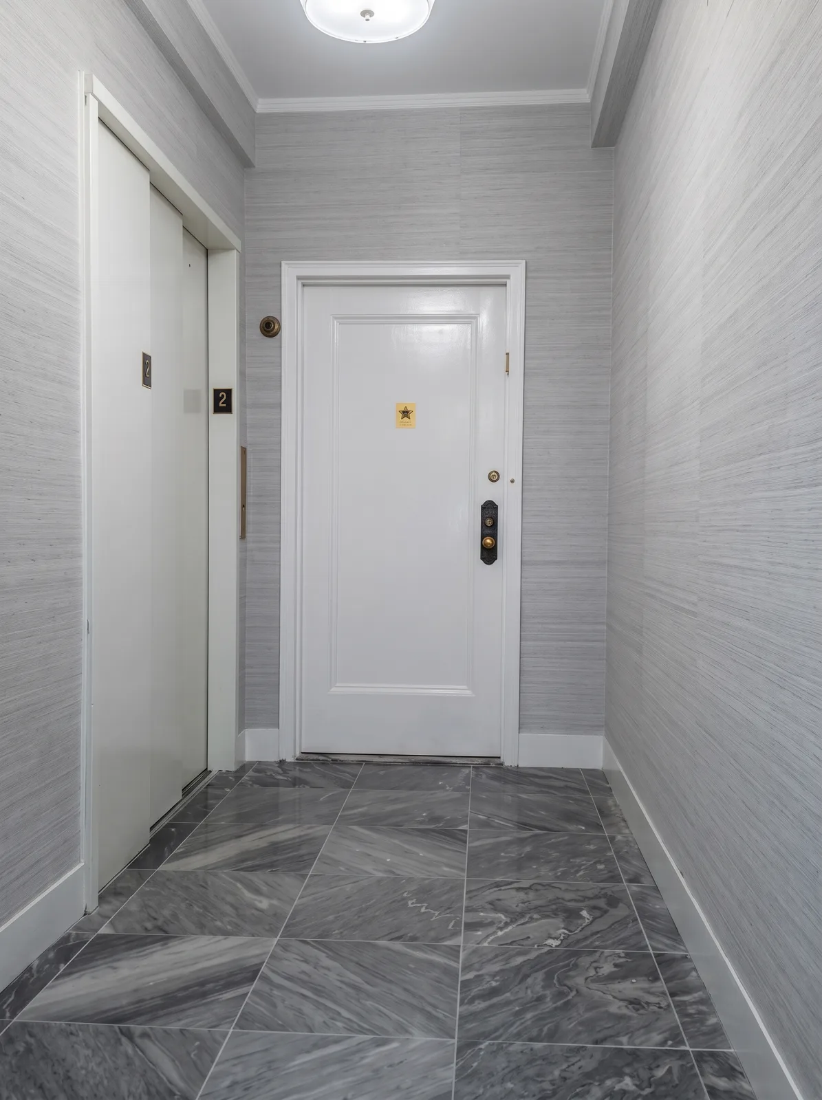 Textured wallpaper and a freshly painted white door in a NYC hallway